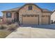 Charming home exterior featuring stone facade and a three car attached garage and a concrete driveway at 23709 E Caleb Pl, Aurora, CO 80016