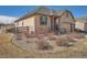 Exterior view of well-maintained landscaping surrounding a stone and siding home with a charming fence at 23709 E Caleb Pl, Aurora, CO 80016