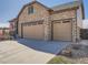 Stunning stone exterior featuring a three car garage and well maintained landscaping at 23709 E Caleb Pl, Aurora, CO 80016