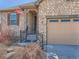 Charming stone exterior with a welcoming front porch and two car garage at 23709 E Caleb Pl, Aurora, CO 80016