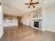 Open-concept living space with stone fireplace, hardwood floors, recessed lights and view into kitchen at 23709 E Caleb Pl, Aurora, CO 80016