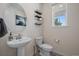 Small powder room with pedestal sink, toilet, and floating shelves at 1161 E Witherspoon Dr, Elizabeth, CO 80107