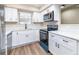 Modern kitchen with white cabinets, stainless steel appliances, and a black faucet at 2716 E Otero Pl # 6, Centennial, CO 80122