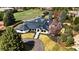 Stunning aerial view of modern home with manicured landscaping, a dark roof, and beautiful trees at 49 Charlou Cir, Cherry Hills Village, CO 80111