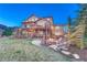 Expansive backyard featuring a stone patio with a fire pit and lush landscaping at 5478 Water Oak Cir, Castle Rock, CO 80108