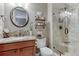 Bathroom featuring a granite countertop vanity with a rounded mirror and a tiled shower with glass doors at 5478 Water Oak Cir, Castle Rock, CO 80108