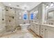 Bright bathroom featuring a soaking tub, separate shower, and double sink vanity with granite countertops at 5478 Water Oak Cir, Castle Rock, CO 80108