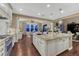 Large kitchen island with seating and sink, white cabinets, and open layout to dining area at 5478 Water Oak Cir, Castle Rock, CO 80108