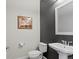 Modern powder room with dark accent wall and white vanity at 9217 E 4Th Pl, Denver, CO 80230