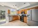 Well-lit kitchen with stainless steel appliances, wooden cabinets, and sliding glass door access at 2141 Coronado N Pkwy # C, Denver, CO 80229