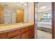 Bathroom features a tile countertop vanity, ample lighting, and a view into the main bedroom at 1868 S Ammons St # D, Lakewood, CO 80232