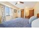 Bright bedroom with a ceiling fan, large window, and access to the bathroom at 1868 S Ammons St # D, Lakewood, CO 80232