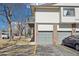 Exterior view of a townhome featuring a private balcony, a brick facade, and attached garages at 1868 S Ammons St # D, Lakewood, CO 80232