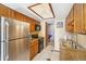 Functional kitchen features stainless steel refrigerator, tiled floors, and wood cabinets at 1868 S Ammons St # D, Lakewood, CO 80232