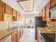 Kitchen features tiled floors, granite counters, wood cabinets, and bright lighting at 1868 S Ammons St # D, Lakewood, CO 80232