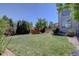 A spacious backyard with green grass and a view of the patio and second story of the home at 973 Orion Way, Castle Rock, CO 80108