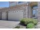 Brick home featuring an attached two-car garage, covered entryway, and manicured front yard at 973 Orion Way, Castle Rock, CO 80108
