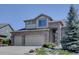 Charming two-story home with a brick facade, spacious two-car garage, and mature landscaping at 973 Orion Way, Castle Rock, CO 80108