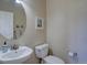Clean and bright half bathroom featuring a modern sink and toilet with a decorative mirror and artwork at 973 Orion Way, Castle Rock, CO 80108