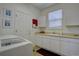 Functional laundry room with white cabinetry, a sink, and plenty of counter space for folding and organizing at 973 Orion Way, Castle Rock, CO 80108
