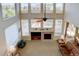 Second-story view of a bright living room featuring a fireplace, high ceilings, and large windows at 973 Orion Way, Castle Rock, CO 80108