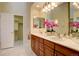 Well-lit bathroom with double sinks, a large mirror, and a walk-in closet for ample storage at 10619 N Osceola Dr, Westminster, CO 80031