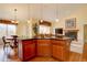 A kitchen island with black granite countertops, pendant lights, and hardwood floors leads to a living room and dining area at 10619 N Osceola Dr, Westminster, CO 80031