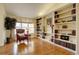 Bright living room with large windows, hardwood floors, built-in shelving, and cozy seating area at 10619 N Osceola Dr, Westminster, CO 80031