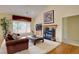 Cozy living room with fireplace, plush rug, and a large window offering backyard views at 10619 N Osceola Dr, Westminster, CO 80031