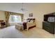 A primary bedroom features a ceiling fan, a window with patterned curtains, and a TV on a stand at 10619 N Osceola Dr, Westminster, CO 80031