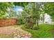 A fenced backyard featuring a rustic gazebo, lush landscaping, and a charming stone path at 3613 Julian St, Denver, CO 80211