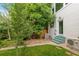 Green backyard and exterior featuring a small patio and air conditioning unit at 3613 Julian St, Denver, CO 80211