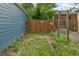 A small area in the backyard with access to a wooden fence and an adjacent blue building at 3613 Julian St, Denver, CO 80211