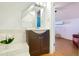 Bathroom with vanity, mirror, tiled tub, and view to bedroom at 3613 Julian St, Denver, CO 80211