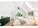 Bright bedroom with wood floors, skylights, neutral decor, and views of the lush green foliage outside at 3613 Julian St, Denver, CO 80211