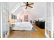 Bright bedroom with skylights, wood floors, a ceiling fan, and French doors to a sitting room at 3613 Julian St, Denver, CO 80211