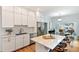 Bright kitchen with white cabinetry, stainless appliances, marble counters, and hardwood floors open to the dining area at 3613 Julian St, Denver, CO 80211