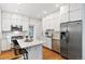 Bright kitchen features white cabinetry, stainless appliances, hardwood floors, and a center island with marble countertop at 3613 Julian St, Denver, CO 80211