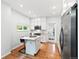 Bright kitchen features white cabinets, stainless appliances, hardwood floors, and a view into the side yard at 3613 Julian St, Denver, CO 80211