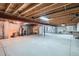 Unfinished basement with exposed beams and a concrete floor, offering potential for customization at 10507 W Maplewood Dr # E, Littleton, CO 80127