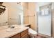 Bathroom featuring a large mirror, vanity with sink, toilet, and shower with glass door at 10507 W Maplewood Dr # E, Littleton, CO 80127