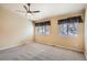 Spacious bedroom with two windows, plush carpet, and a ceiling fan at 10507 W Maplewood Dr # E, Littleton, CO 80127