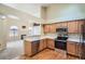Well-equipped kitchen with stainless steel appliances, wood cabinets and hardwood floors, open to living area at 10507 W Maplewood Dr # E, Littleton, CO 80127