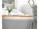 Bright bathroom featuring a freestanding soaking tub with a bamboo tray and natural light from a large window at 19887 Kershaw Ct, Monument, CO 80132