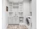 Bright laundry room featuring a sink, white cabinetry, decorative flooring, and a modern washer and dryer at 19887 Kershaw Ct, Monument, CO 80132