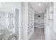Luxurious bathroom leading into a walk-in closet with custom built-in shelving and storage at 19887 Kershaw Ct, Monument, CO 80132