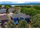 The backyard patio has a table with a blue umbrella and surrounding greenery, with a lake in the background at 3142 Captains Ln, Longmont, CO 80503