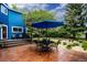 This backyard patio has a table with four chairs, a blue umbrella and well maintained greenery at 3142 Captains Ln, Longmont, CO 80503
