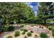 A stone walkway leads to a stone seating area, surrounded by mulch and shrubbery in the backyard at 3142 Captains Ln, Longmont, CO 80503