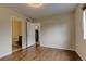 Bedroom featuring hardwood floors, neutral paint, and open access to both a bathroom and closet space at 3142 Captains Ln, Longmont, CO 80503